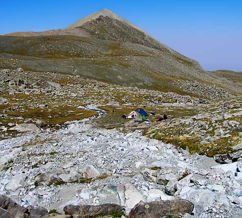 Палатка у горной реки в конце маршрута